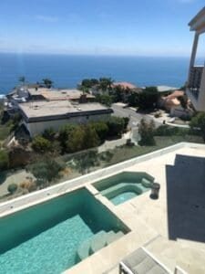 Scenic coastal view with swimming pool and ocean in the background.