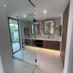 Contemporary bathroom with double mirror vanity and walk-in shower.