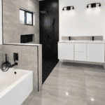 Contemporary bathroom featuring a tile shower, bathtub, and sleek vanity with black fixtures.