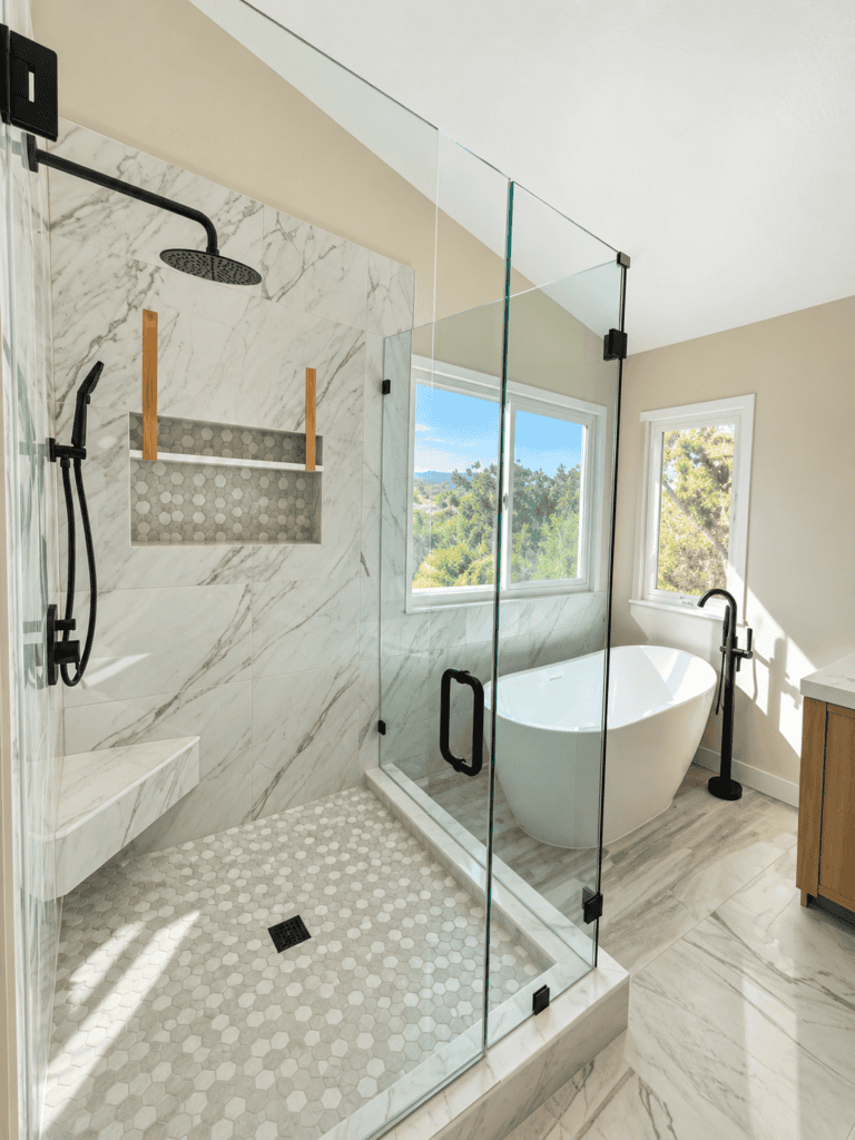 Modern bathroom with glass shower enclosure and freestanding bathtub.