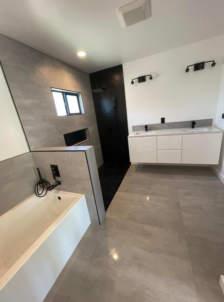 Modern bathroom with gray tiles, black accents, and a white vanity.